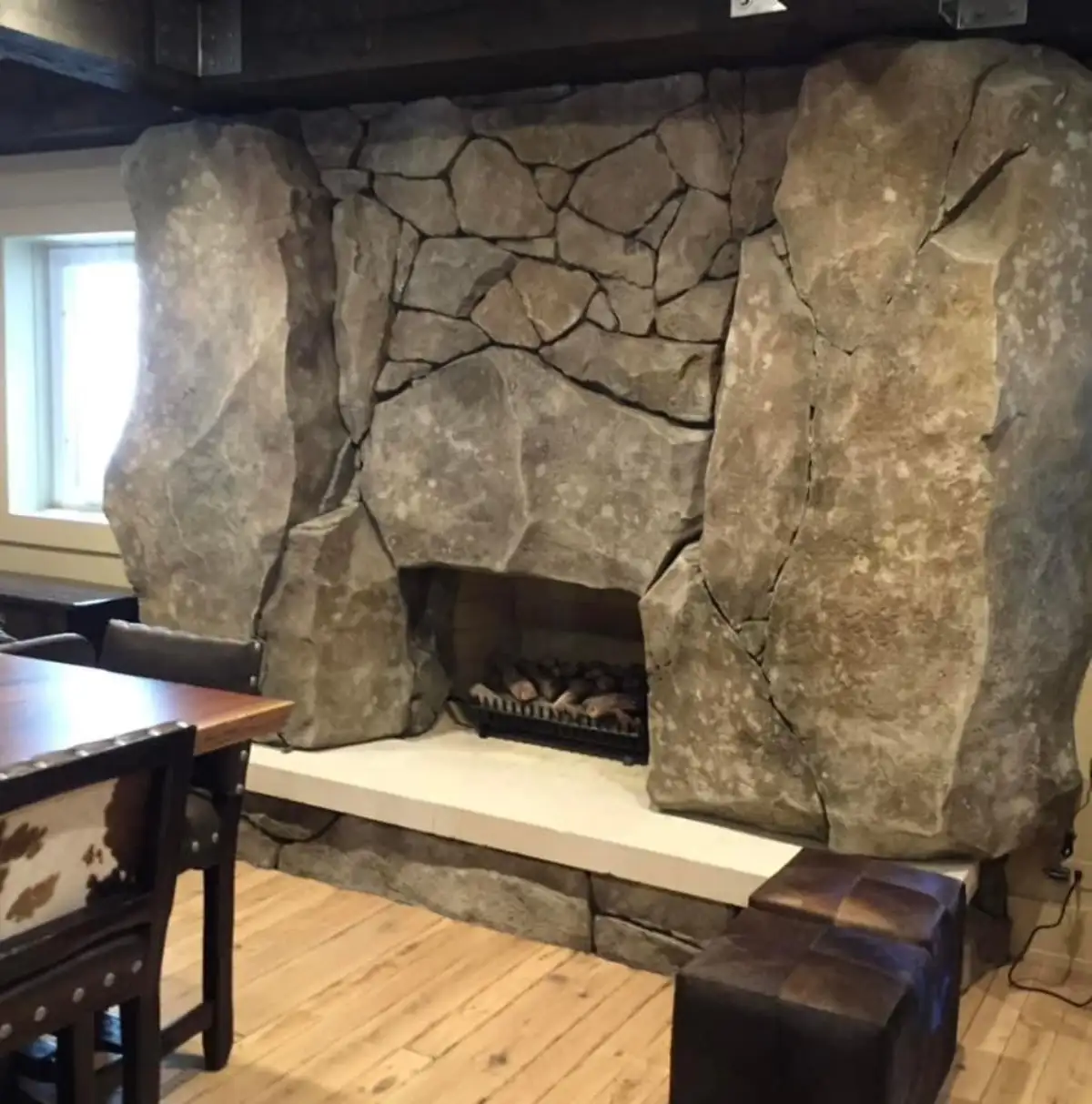 Hand-sculpted indoor fireplace with faux rock surround by Boulder Legacies