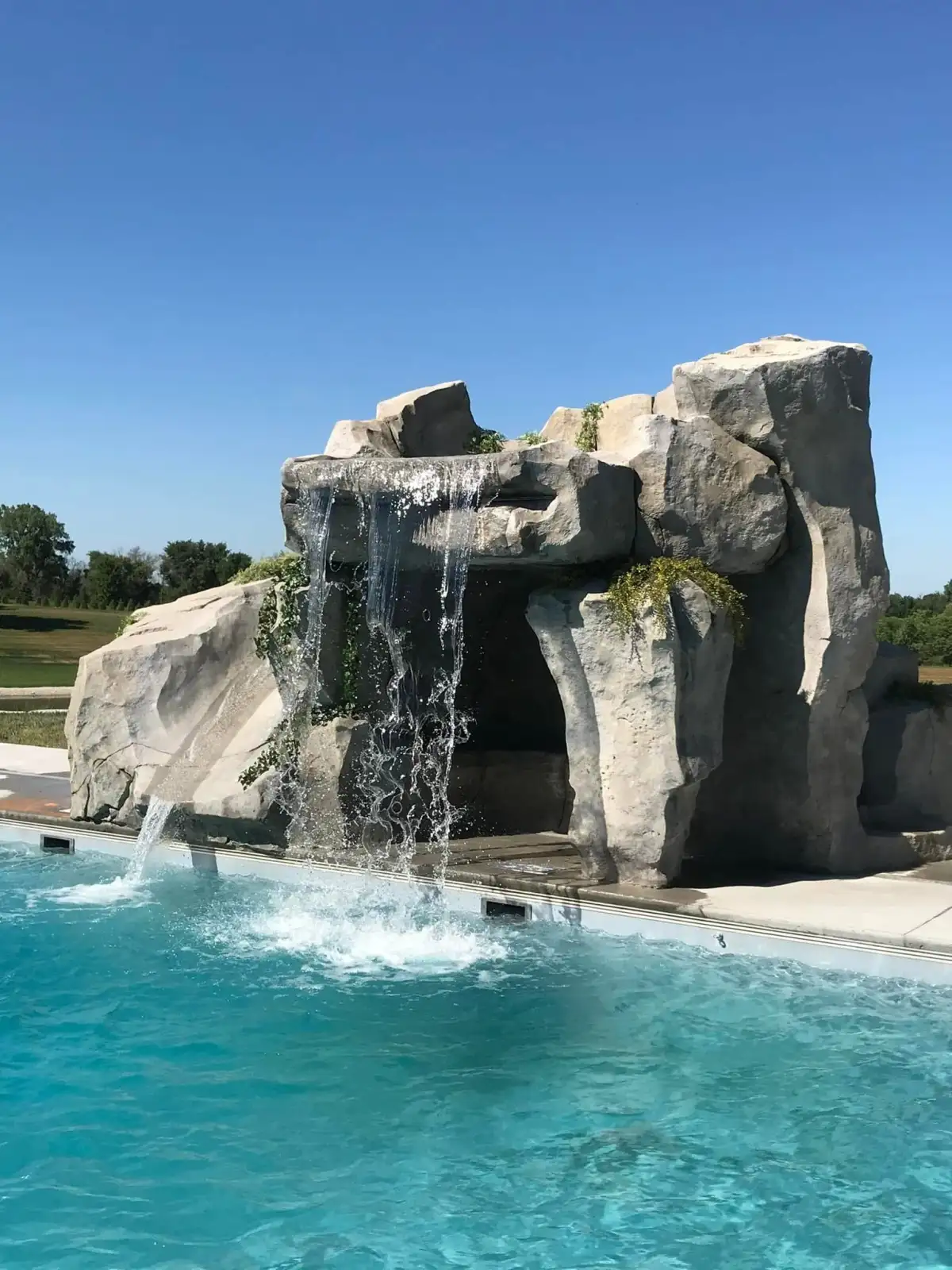 Walk-through pool grotto with waterfall cascade and interior cave seating