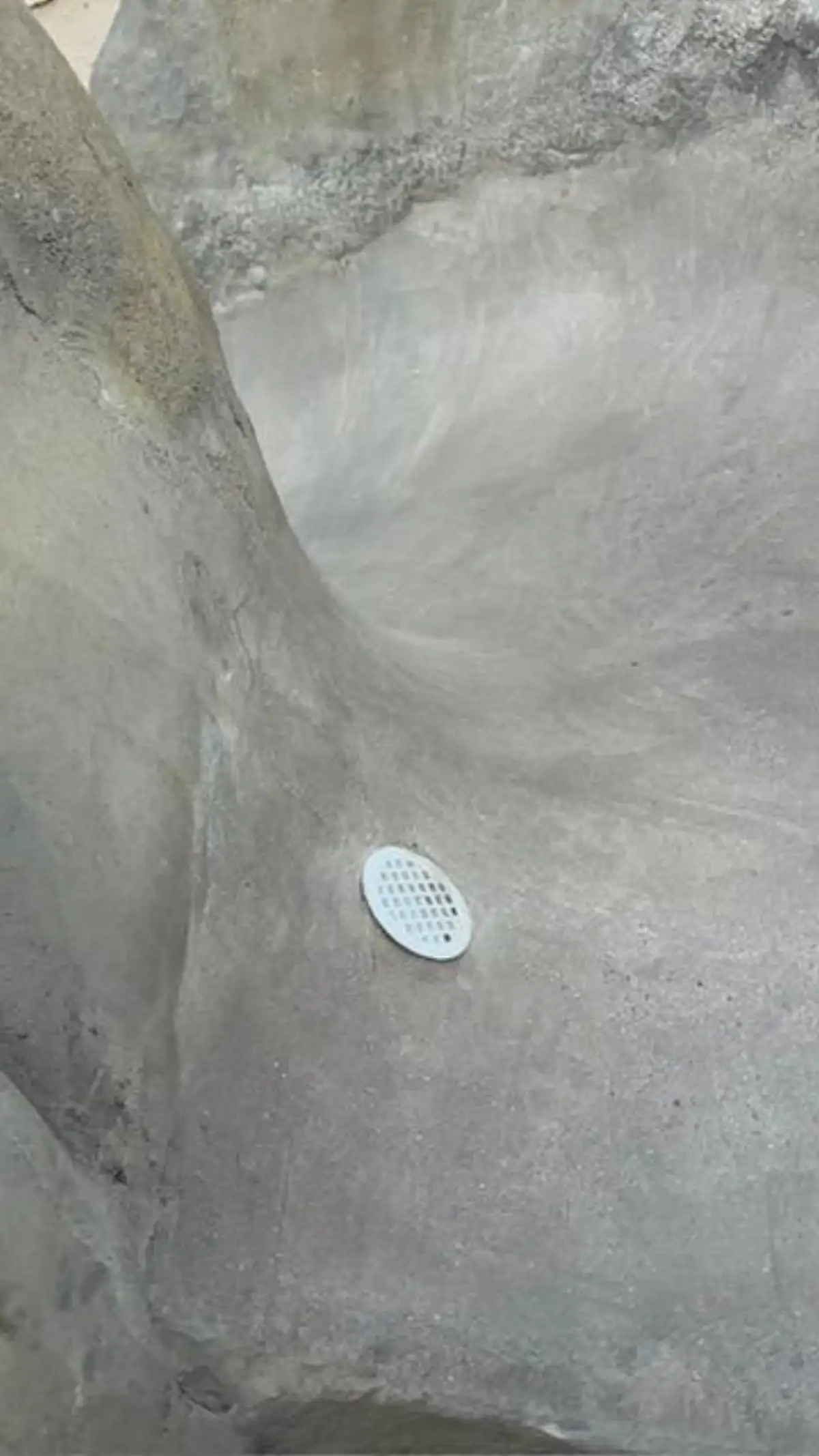 Completed polished concrete slide installation showing full rock formation and pool