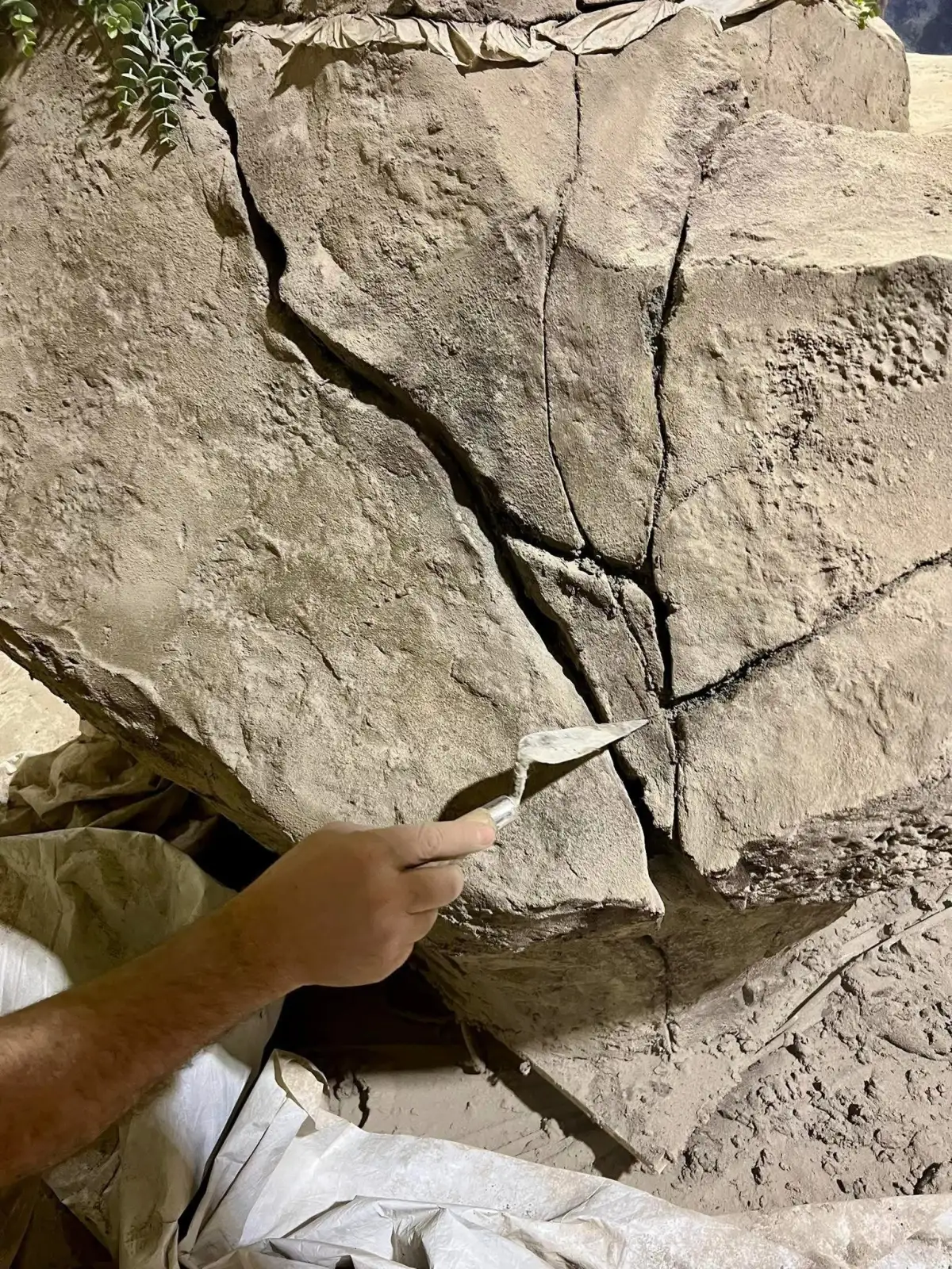Close-up of hand sculpting detail work on sculpting mortar surface